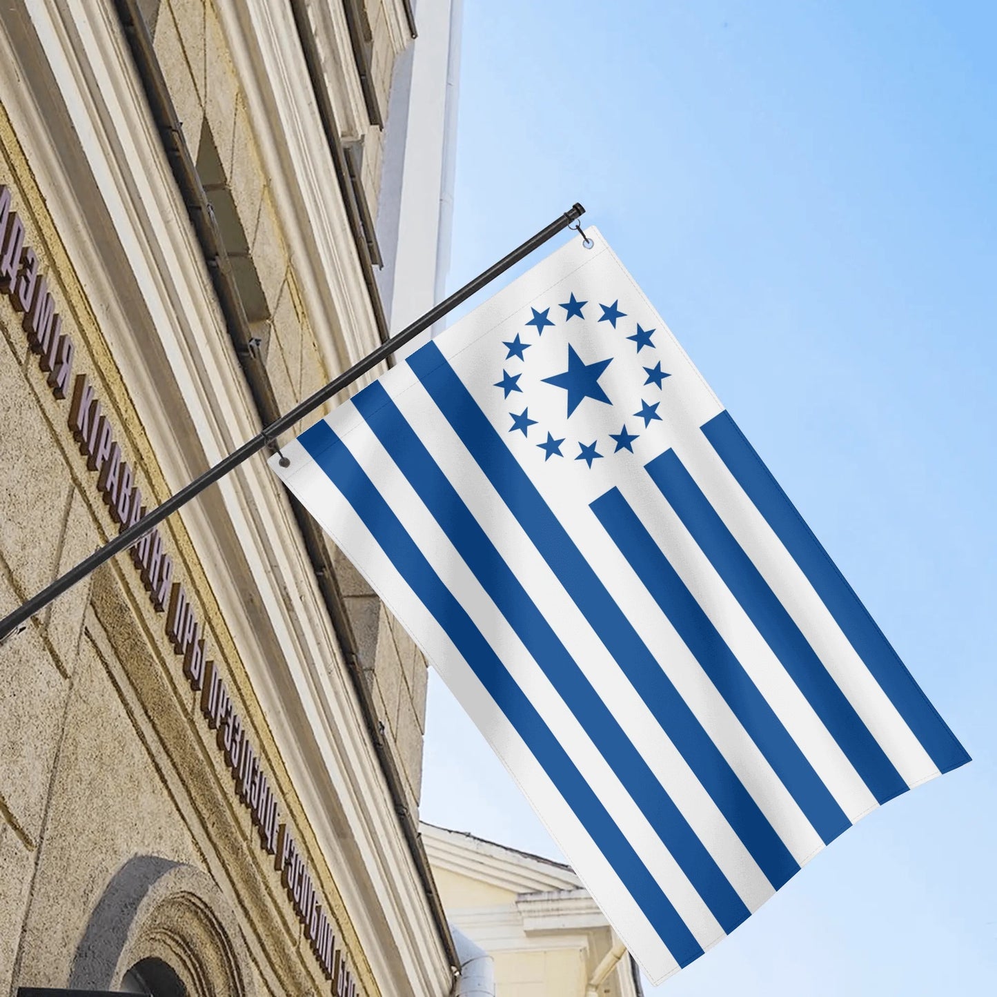 A Deseret flag with horizontal blue and white stripes, featuring a star in the center, displayed against an outdoor backdrop.