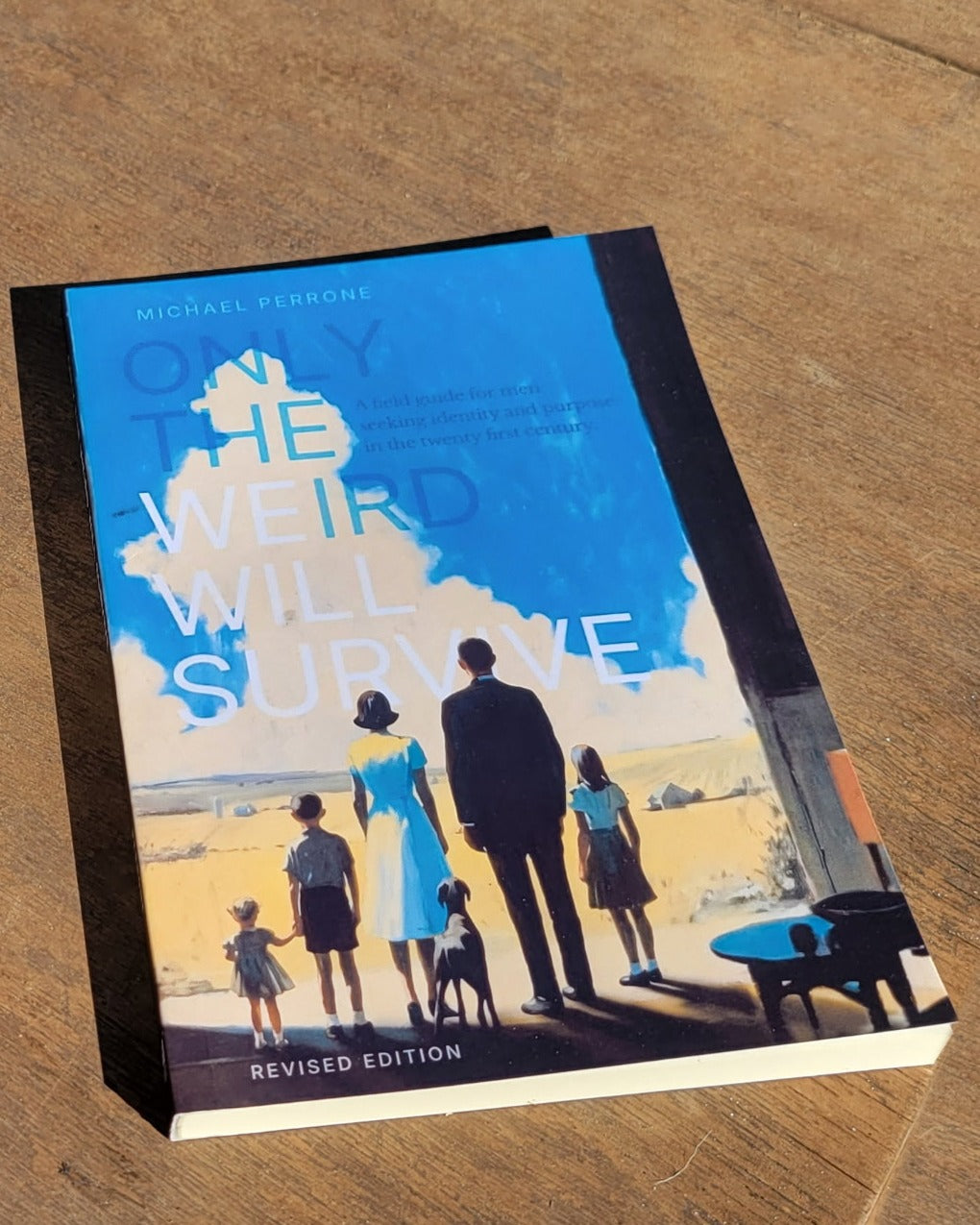 Paperback copy of Only the Weird Will Survive, Revised Edition, on a sunlit wooden table