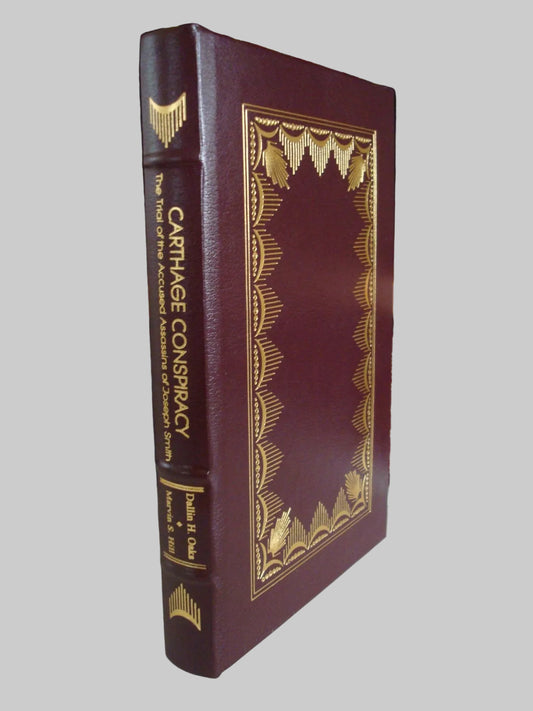 Book titled 'Carthage Conspiracy' with decorative cover on a bookshelf background