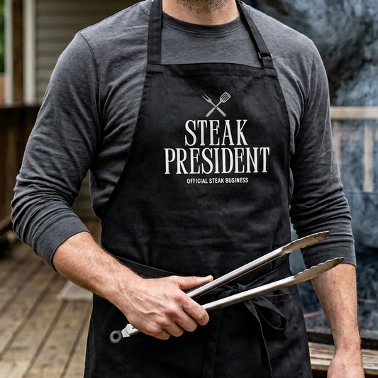 A man wearing a black Steak President apron