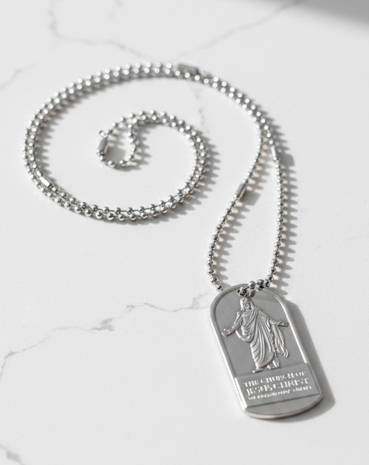 A silver-toned dog tag pendant necklace with a Christ engraving with the name of the Church of Jesus Christ of Latter-day Saints. Features a ball chain.